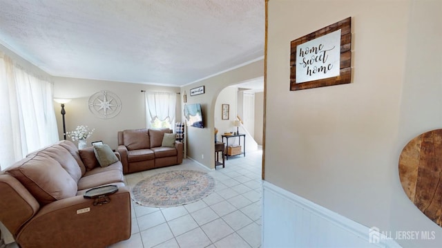 68 Applegate Ave, Monroe, NJ 08831 - living area with arched walkways, light tile patterned floors, a wainscoted wall, and a textured ceiling