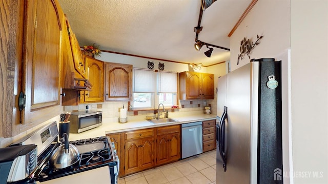 68 Applegate Ave, Monroe, NJ 08831 - kitchen featuring appliances with stainless steel finishes, a sink, brown cabinetry, tasteful backsplash, and a textured ceiling