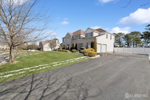 view of front of property with a garage, a front yard, driveway, and fence