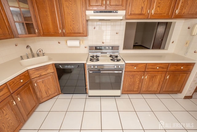 kitchen with white gas stove, light countertops, a sink, dishwasher, and under cabinet range hood