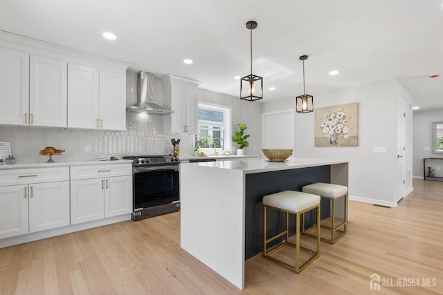 39 S Pierson Rd, Maplewood, NJ 07040 - kitchen with wall chimney range hood, stainless steel range, a center island, light wood-type flooring, and recessed lighting
