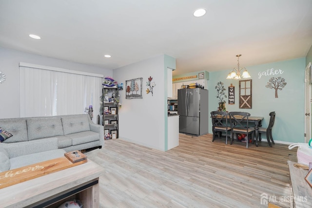 living room featuring a chandelier and light hardwood / wood-style floors