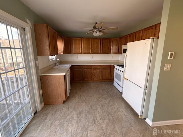 kitchen featuring ceiling fan, white appliances, and sink