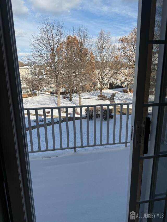 view of snow covered back of property