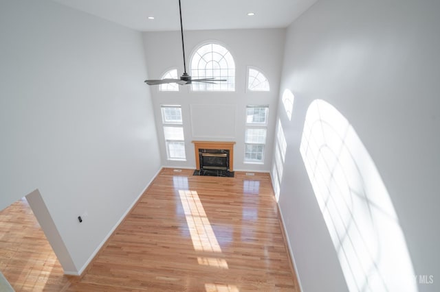 unfurnished living room with plenty of natural light, light wood-style floors, and baseboards