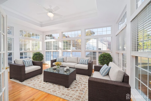 sunroom / solarium with ceiling fan and a tray ceiling