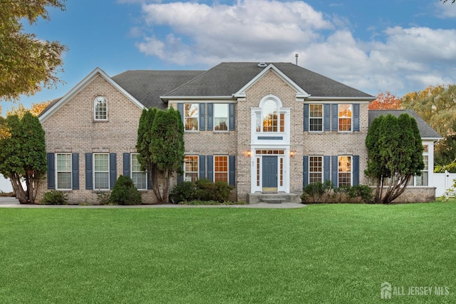 view of front facade featuring brick siding and a front lawn