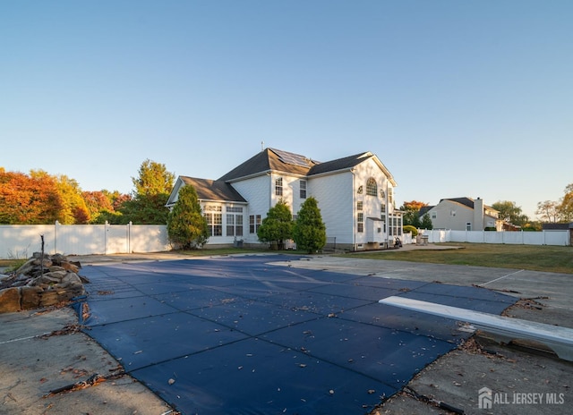 view of pool with a diving board, a yard, a fenced in pool, and fence