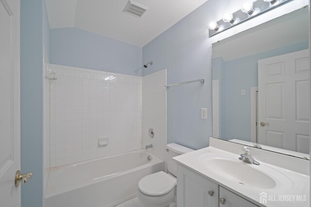 full bath featuring vanity, visible vents, vaulted ceiling, bathing tub / shower combination, and toilet