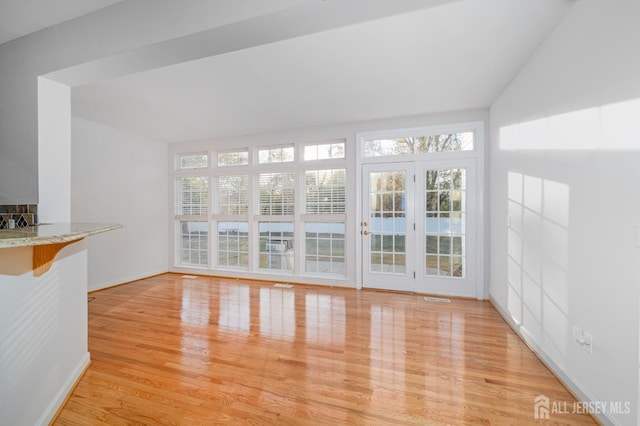 unfurnished living room featuring visible vents, baseboards, and light wood-style floors