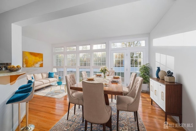 dining room featuring lofted ceiling and light wood finished floors