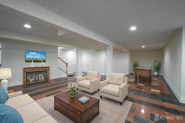 living area featuring granite finish floor, recessed lighting, baseboards, and a premium fireplace