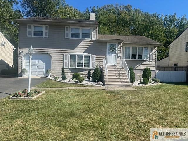 split level home featuring a front lawn and a garage