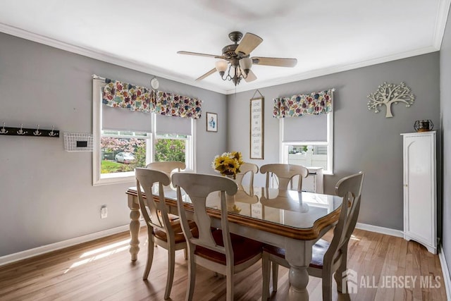 dining space with ceiling fan, ornamental molding, baseboards, and light wood-type flooring