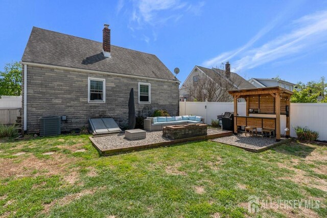 back of property with a yard, outdoor lounge area, a fenced backyard, and a patio area