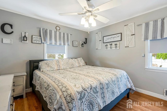 bedroom featuring crown molding, baseboards, and wood finished floors