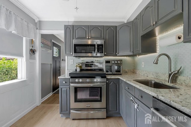 kitchen featuring a sink, appliances with stainless steel finishes, tasteful backsplash, and gray cabinetry