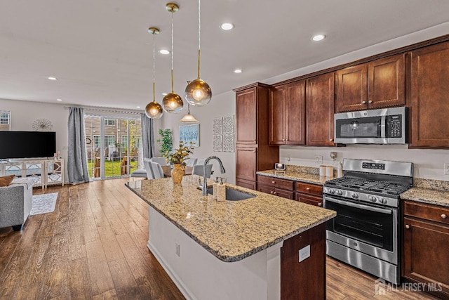 22 Larkspur Ln, Monroe, NJ 08831 - kitchen featuring appliances with stainless steel finishes, open floor plan, a center island with sink, light stone countertops, and dark wood-type flooring