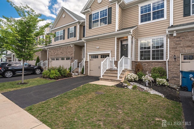 22 Larkspur Ln, Monroe, NJ 08831 - multi unit property with a garage, asphalt driveway, stone siding, and a front yard