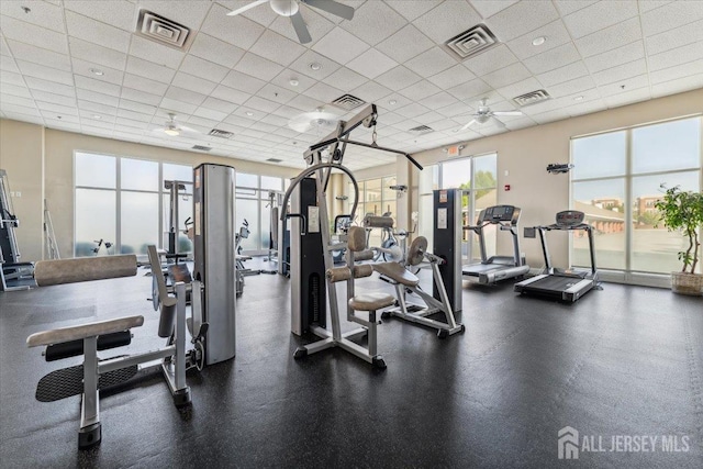 workout area featuring a ceiling fan and a drop ceiling