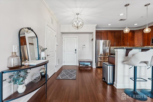 foyer entrance with dark wood-style flooring, baseboards, recessed lighting, a chandelier, and ornamental molding