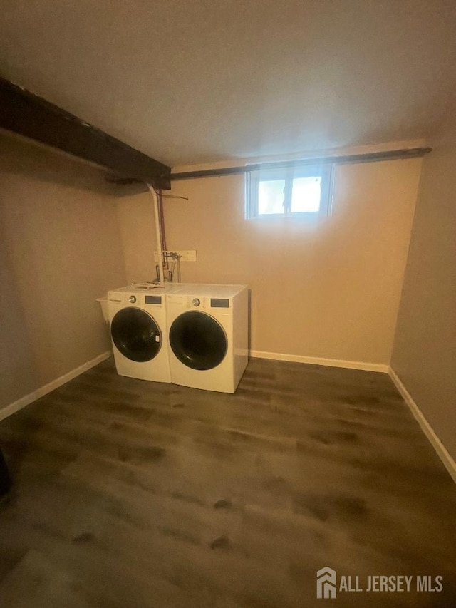 laundry room with dark wood finished floors, laundry area, baseboards, and washer and clothes dryer