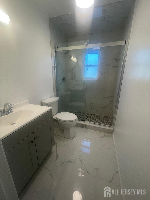 full bathroom with toilet, marble finish floor, a marble finish shower, baseboards, and vanity