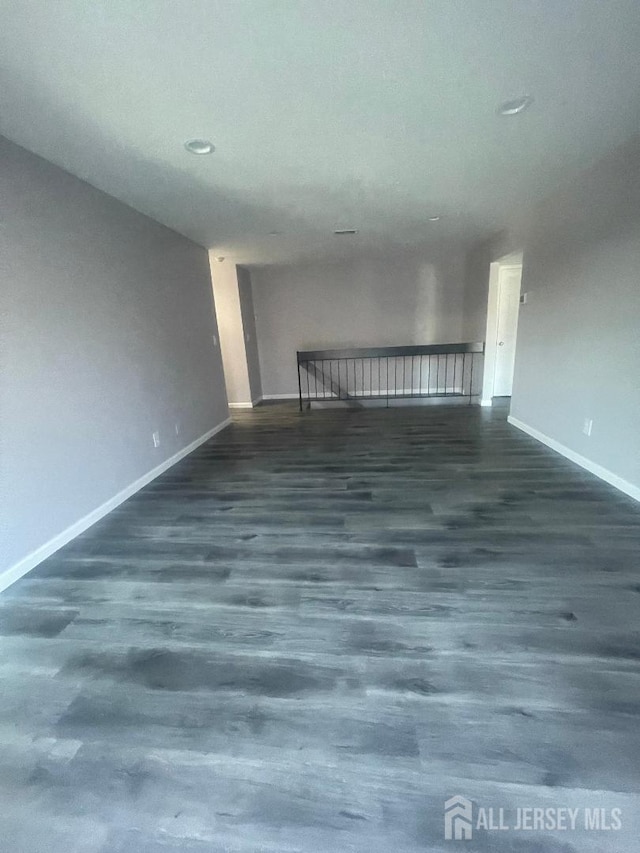 unfurnished room featuring baseboards and wood finished floors