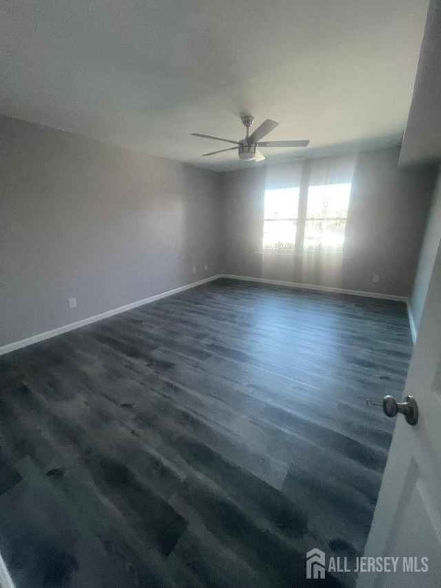 unfurnished room featuring ceiling fan, baseboards, and dark wood-style floors