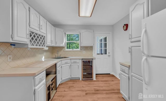 74 Ravine Dr, Matawan, NJ 07747 - kitchen featuring freestanding refrigerator, wine cooler, light wood-style flooring, and white cabinets
