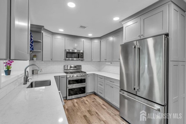 74 Ravine Dr, Matawan, NJ 07747 - kitchen featuring appliances with stainless steel finishes, gray cabinets, open shelves, backsplash, and light stone countertops