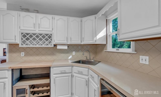 74 Ravine Dr, Matawan, NJ 07747 - kitchen featuring white cabinetry, light countertops, tasteful backsplash, and beverage cooler