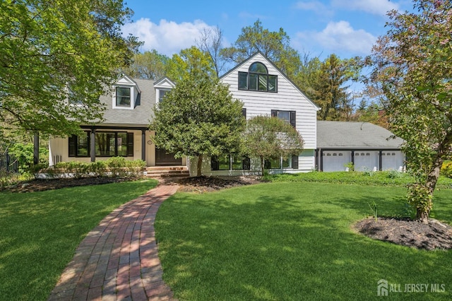 view of front of home featuring a shingled roof, an attached garage, and a front yard