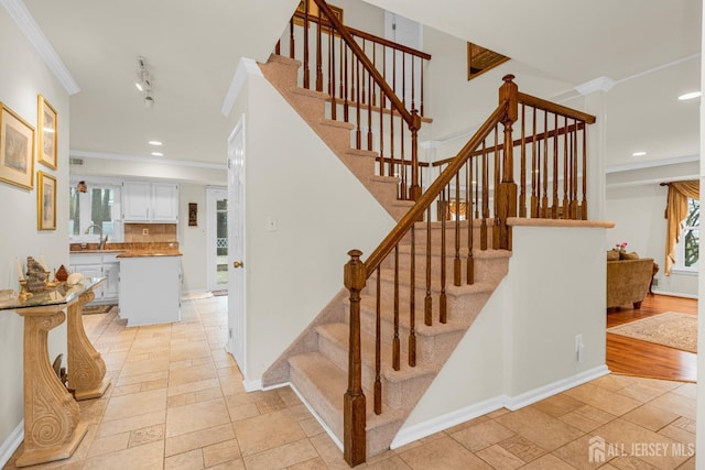 stairway featuring recessed lighting, crown molding, baseboards, and stone tile floors