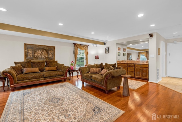living room featuring recessed lighting, light wood finished floors, and crown molding