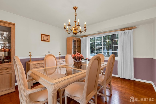 dining area featuring a chandelier, baseboards, dark wood-type flooring, and visible vents