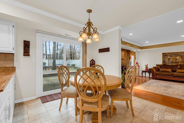 dining space with crown molding, recessed lighting, baseboards, and an inviting chandelier