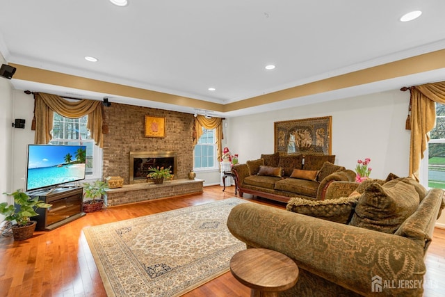 living area featuring ornamental molding, recessed lighting, plenty of natural light, and wood finished floors