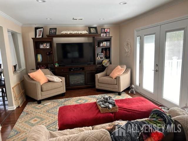 living area with french doors, crown molding, and wood finished floors