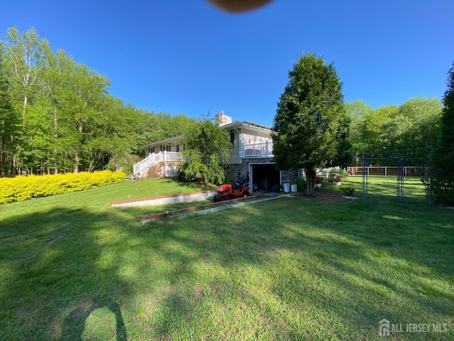 view of yard with stairs, a gate, and an attached garage