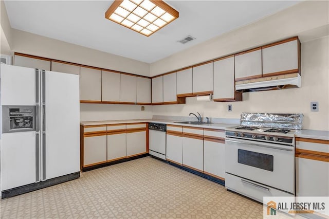 kitchen featuring white appliances, visible vents, a sink, light countertops, and under cabinet range hood