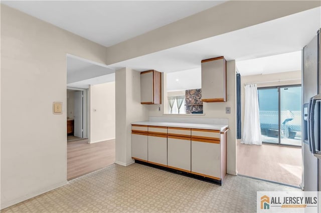 kitchen with a wealth of natural light, baseboards, light floors, and light countertops