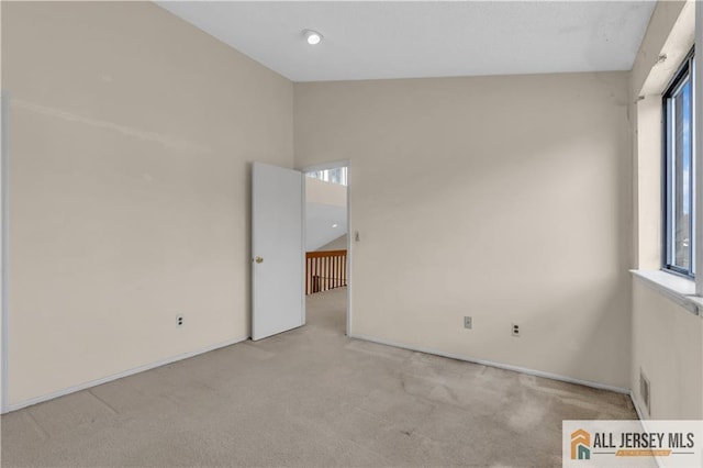 unfurnished room featuring vaulted ceiling, visible vents, and carpet floors