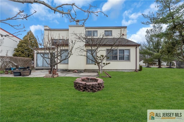 rear view of property featuring a patio, a lawn, and an outdoor fire pit