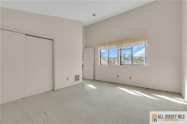 unfurnished bedroom featuring visible vents, carpet floors, and a closet