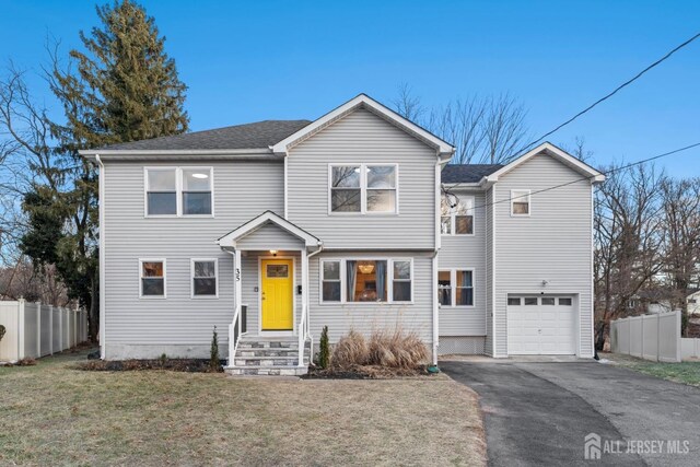 view of property with a garage and a front lawn