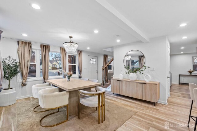 dining area featuring beam ceiling, a chandelier, and light wood-type flooring