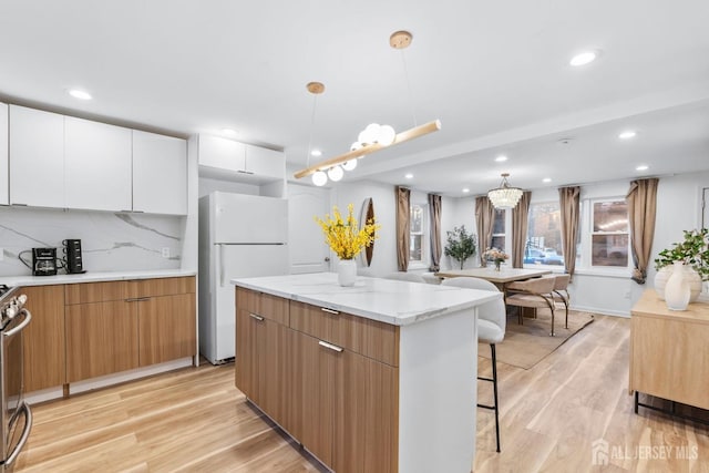 kitchen featuring light wood-type flooring, modern cabinets, and freestanding refrigerator