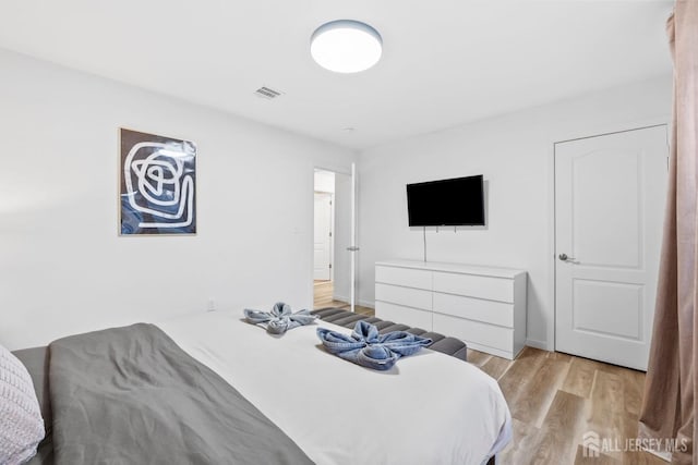 bedroom with light wood-style flooring and visible vents