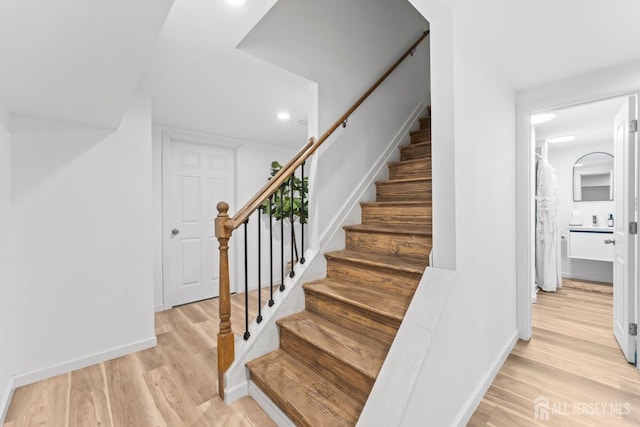 staircase with baseboards and wood finished floors